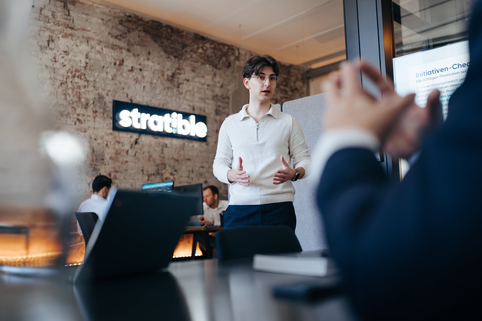 stratible Kollege präsentiert vor dem Team mit Laptops im Office