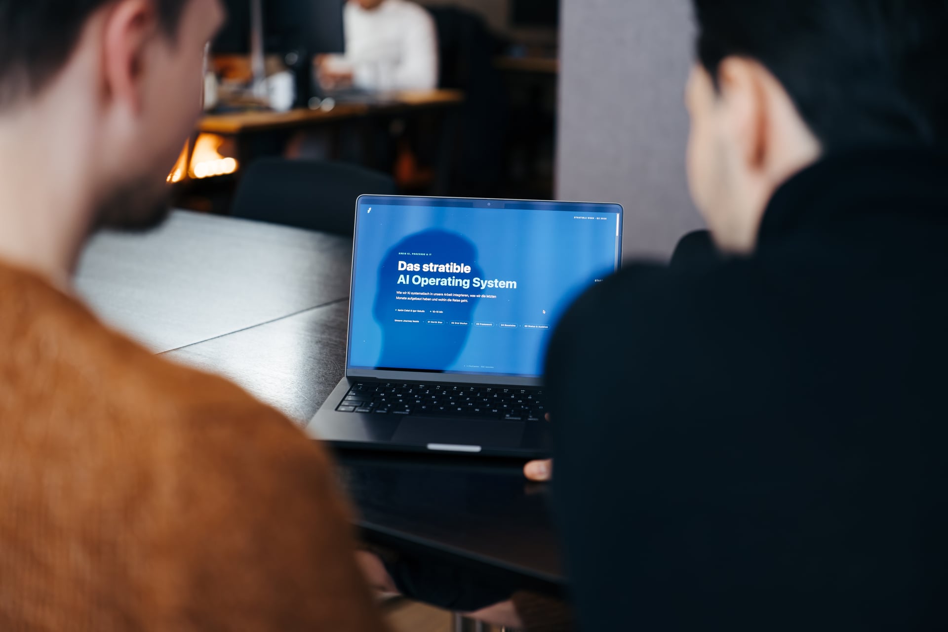 stratible Kollege arbeitet am Laptop am AI Operating System