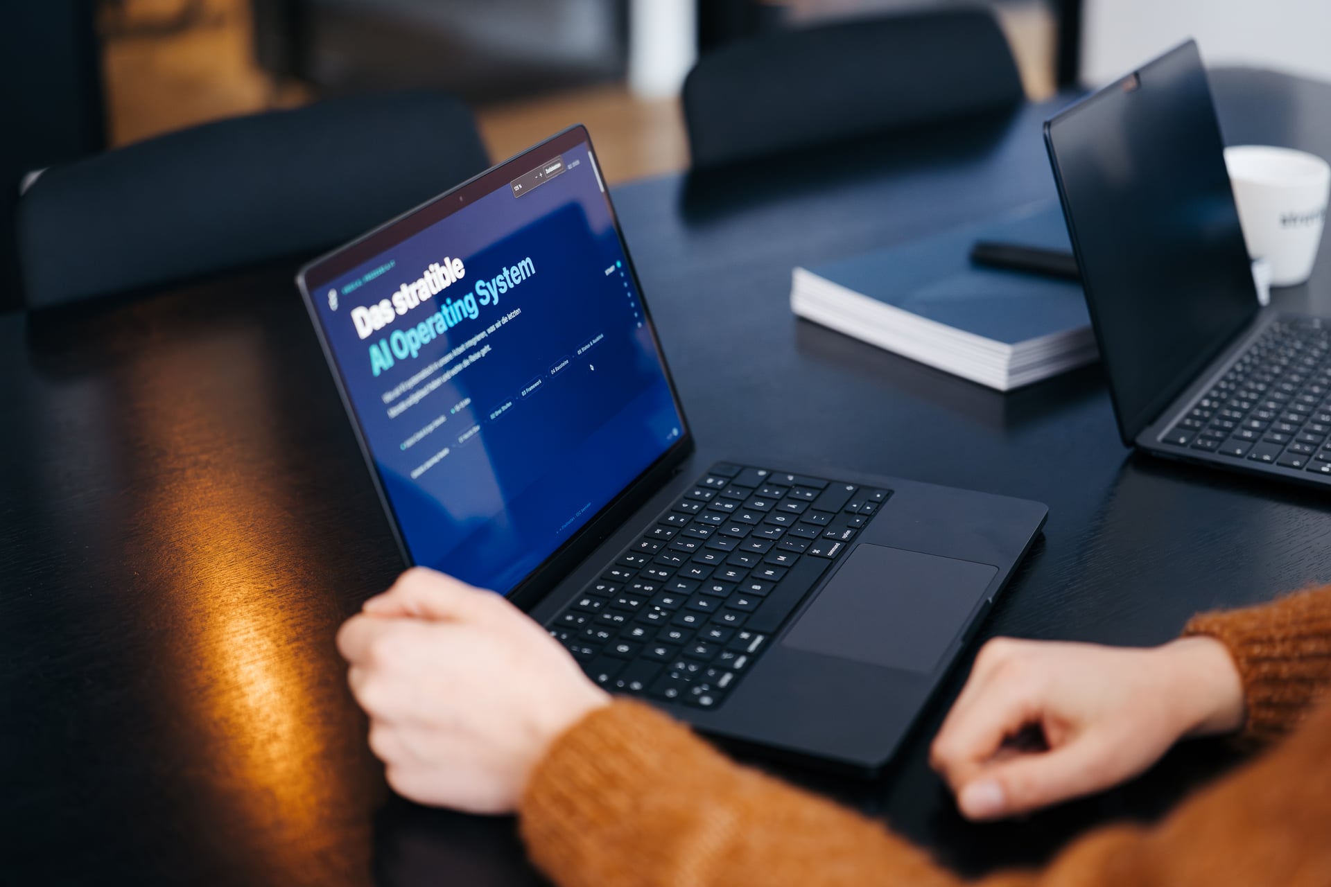 Hände tippen auf einer Tastatur mit dem stratible AI Operating System am Bildschirm
