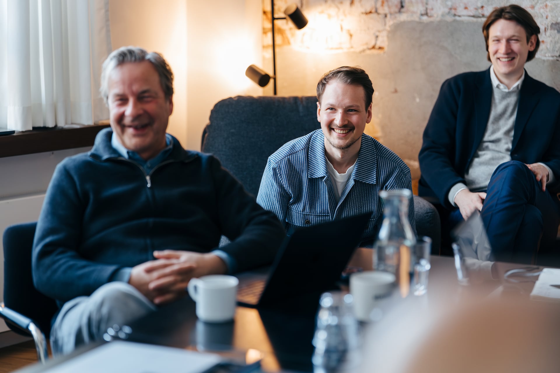 Zwei stratible Kollegen lachen entspannt in der Lounge