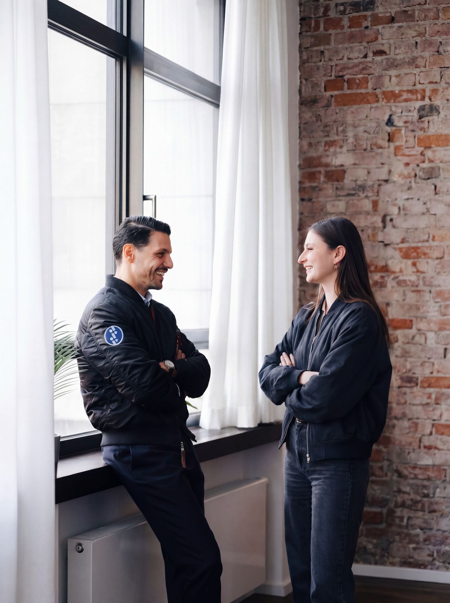 Kerim Cekel, Managing Partner bei stratible, im Gespräch mit einer Kollegin am Fenster